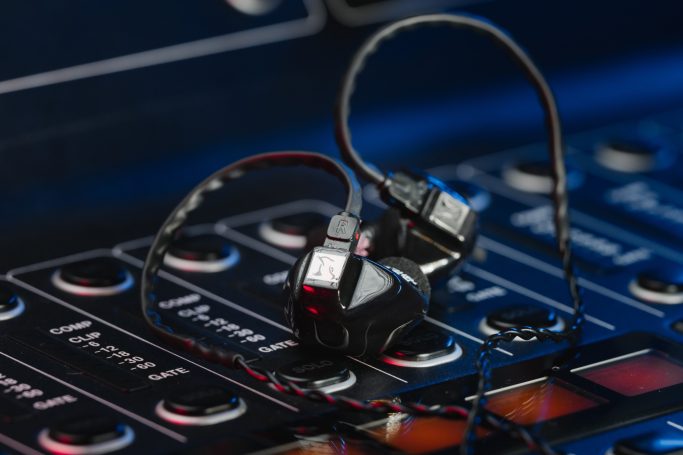 Schwarze Monitoring-Hörer von Hörlcuhs auf einem Mischpult platziert, zur Veranschaulichung im professionellen Audio-Umfeld.