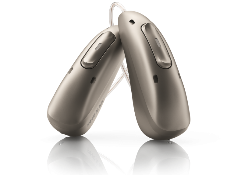 Zwei moderne Hörgeräte in silberner Farbe, nebeneinander positioniert.