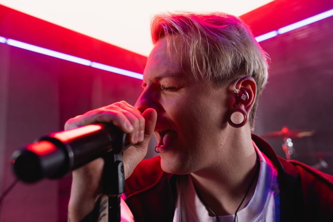 Live-Performance eines Sängers mit Hörluchs In-Ear-Monitoring zur Demonstration von sicherem Sitz unter extremen Bühnenbedingungen.