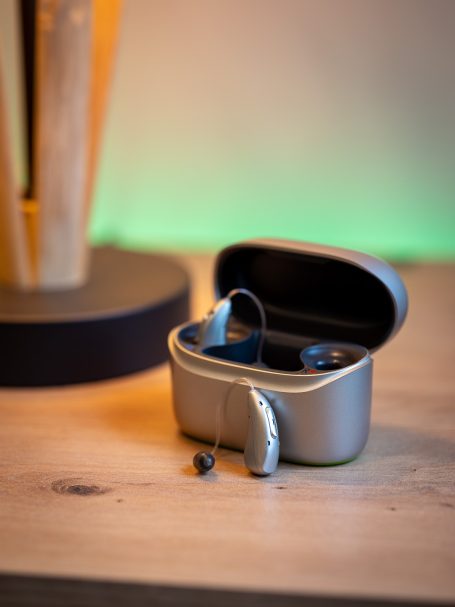 Geöffnetes Charger-Case mit eingesetzten Phonak Audéo Infinio Hörgeräten zur Demonstration der Akku-Technologie.