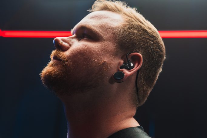 Seitenprofil eines Anwenders mit diskret sitzenden schwarzen In-Ear-Hörern von Hörluchs zur Demonstration von Passform und Ästhetik.