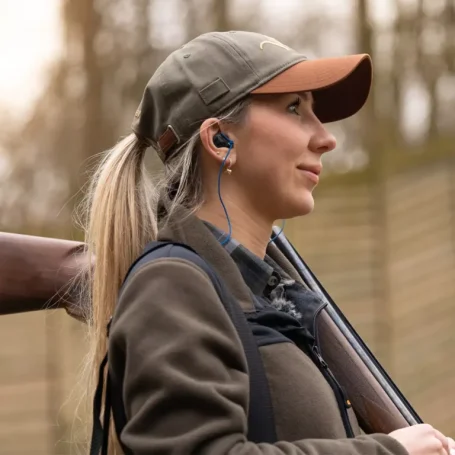 Jägerin mit eingesetztem maßgefertigten Hörluchs Gehörschutz zur Veranschaulichung von Ergonomie und Kommunikationstauglichkeit im Feld.