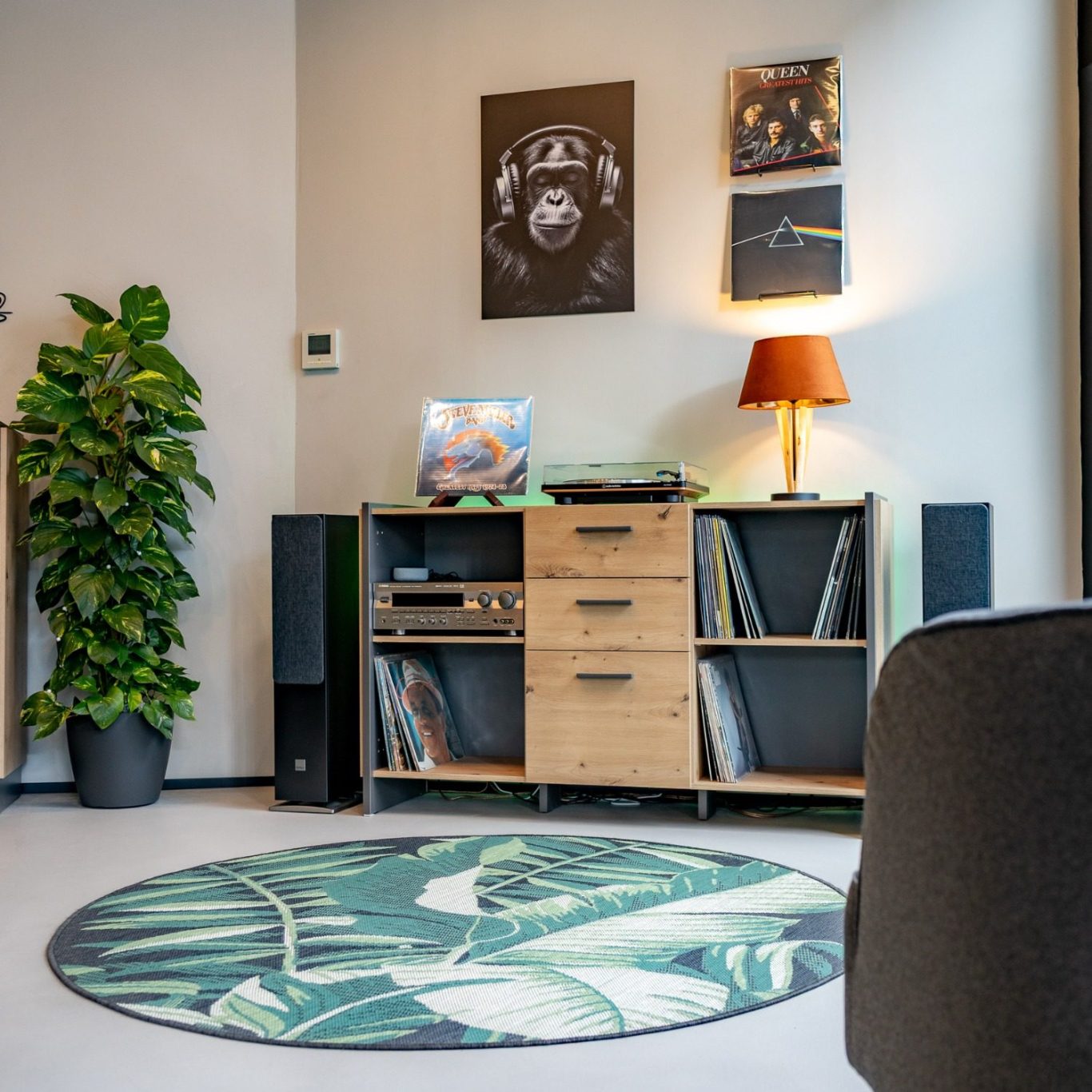 Wartebereich bei OhrPunkt Hörgeräte mit einem Plattenspieler, Lautsprecher, eine Lampe und Pflanzen. 