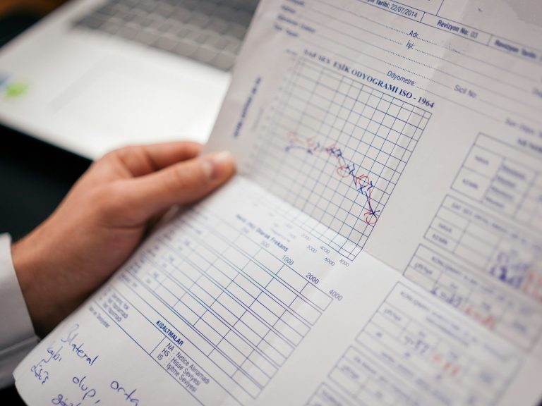 Ein Hand hält ein Blatt mit den Ergebnissen eines Hörtests.